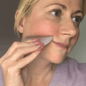 The skinologist showing you how to lift with Gua Sha Tool.
