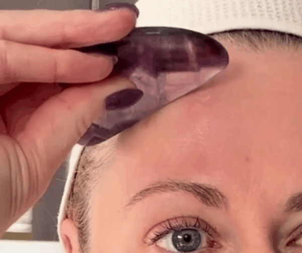 The Skinologist lifting brow with Gua Sha tool.